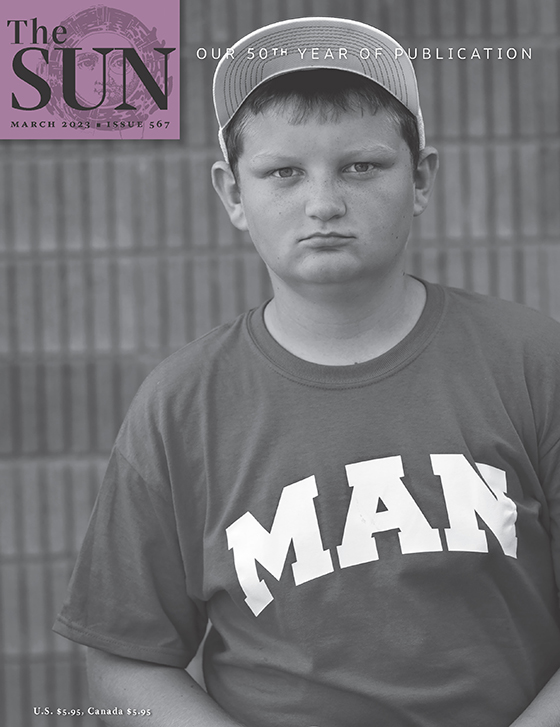 March 2023 cover of The Sun. At a baseball tournament in Kentucky, a serious-looking boy looks into the camera. He is wearing a baseball cap and T-shirt with “MAN” written in capital letters. The boy’s team is from Man, West Virginia.